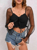 a woman wearing a black top and denim shorts