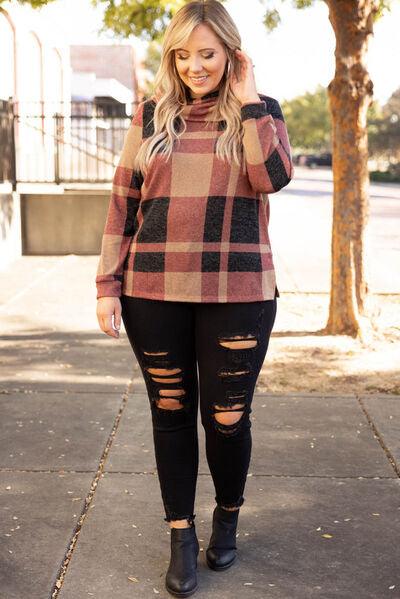 a woman wearing a plaid sweater and ripped jeans