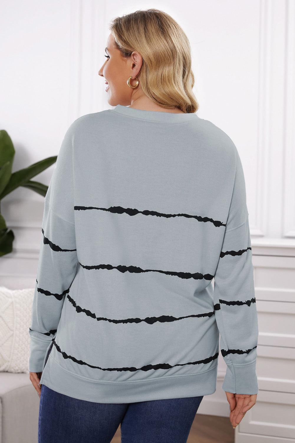 a woman wearing a grey sweater with black stripes