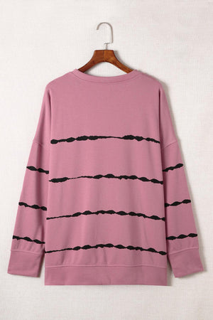 a pink sweater with black lines on it