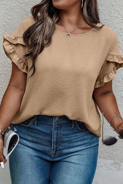 a woman wearing a tan top and jeans