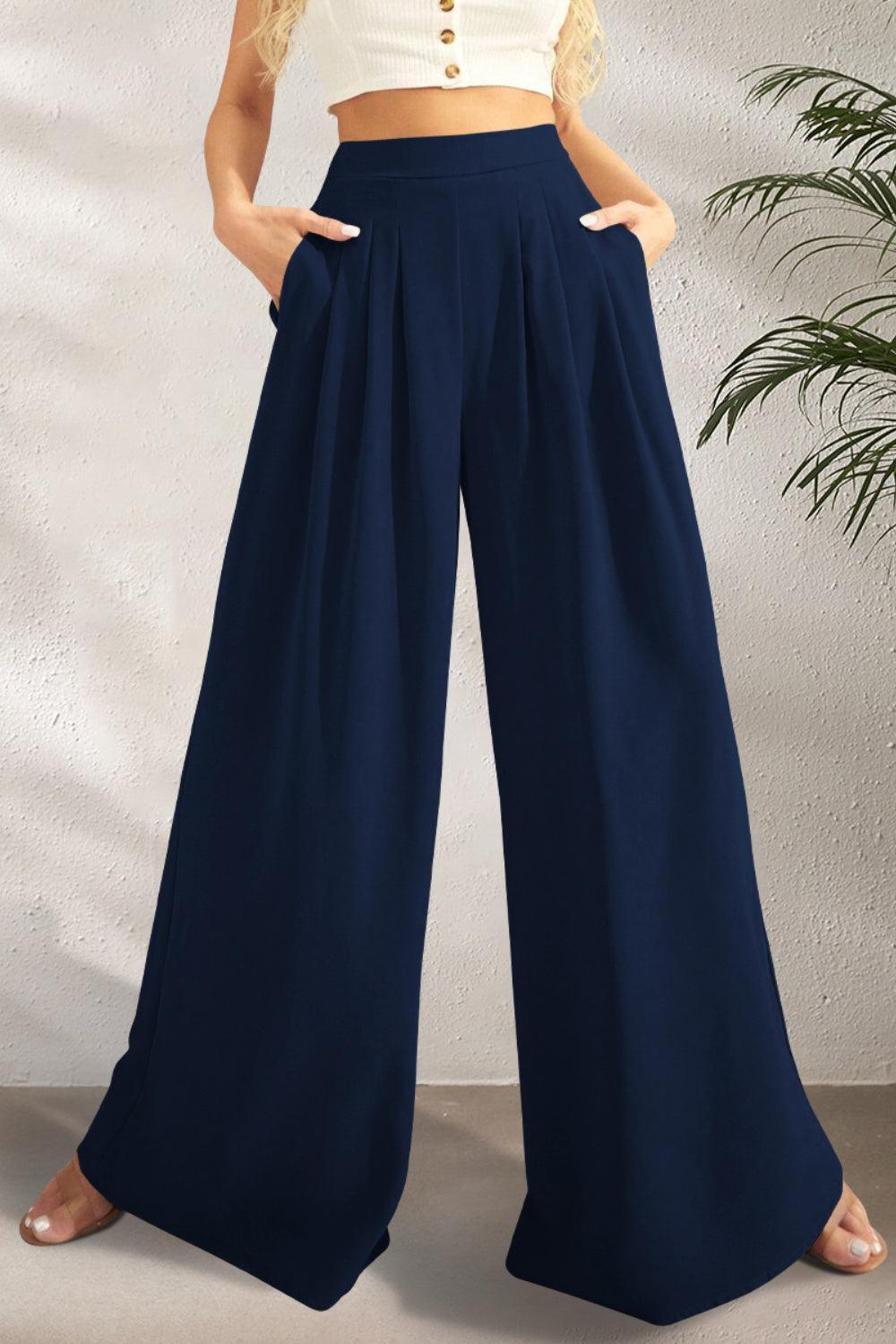 a woman wearing a crop top and wide legged pants