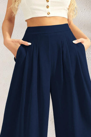 a woman wearing a crop top and wide legged pants