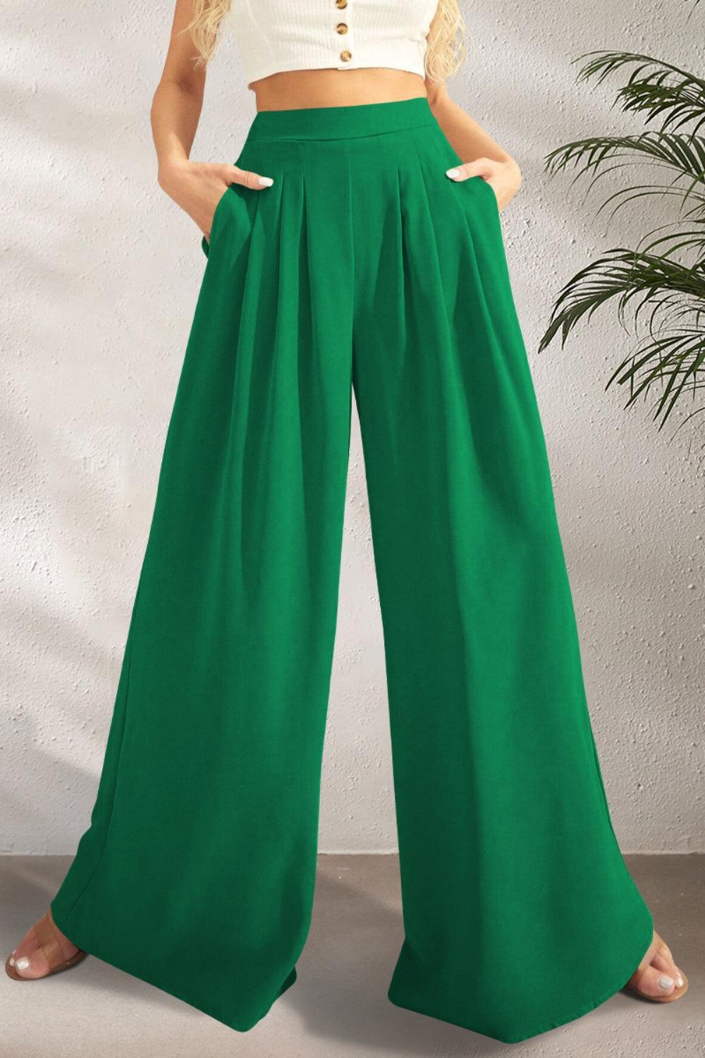 a woman in a white crop top and green pants