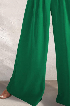 a woman wearing a green pants and sandals