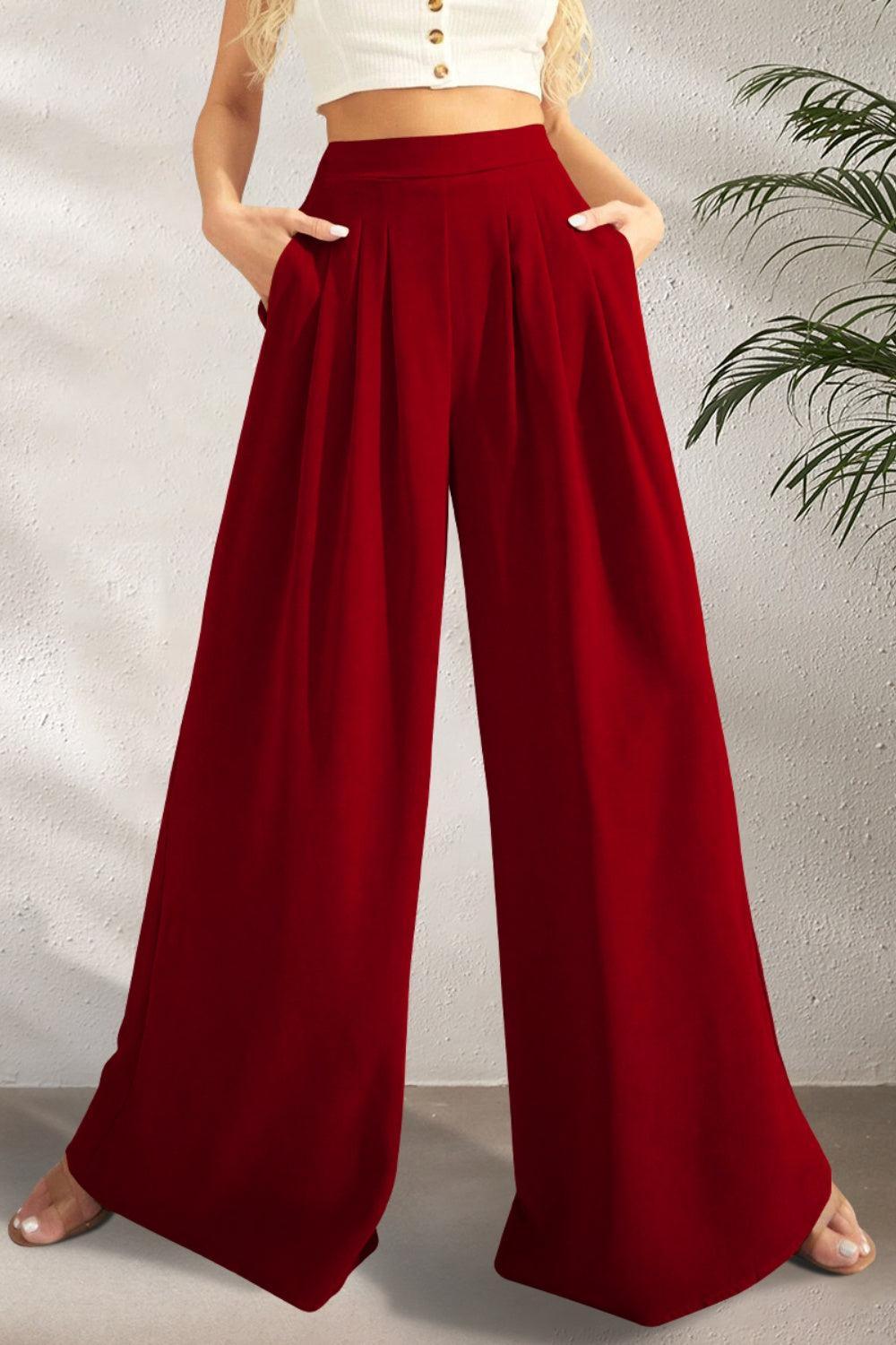 a woman in a white crop top and red wide legged pants