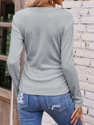 a woman wearing a gray sweater and jeans