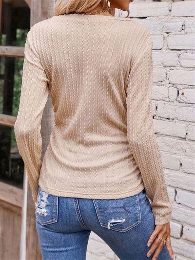 a woman wearing a tan sweater and jeans