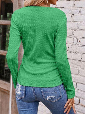 a woman wearing a green sweater and jeans