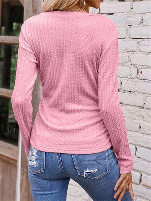 a woman wearing a pink sweater and jeans