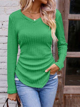 a woman wearing a green sweater and jeans