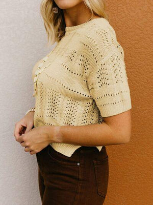 a woman wearing a tan sweater and brown pants