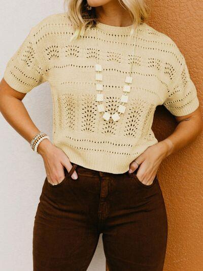 a woman wearing brown pants and a beige sweater