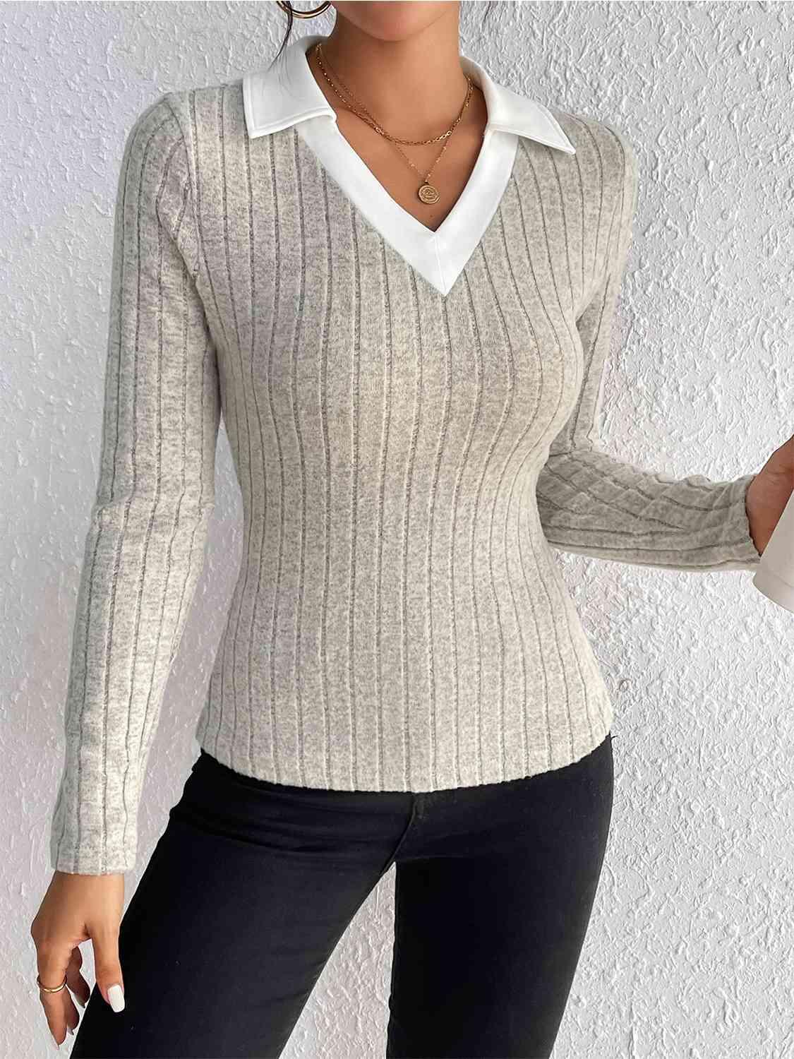 a woman wearing a white sweater and black pants