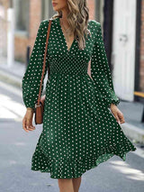 a woman walking down a street wearing a green polka dot dress