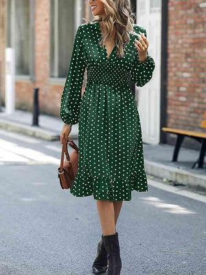 a woman in a green dress is walking down the street