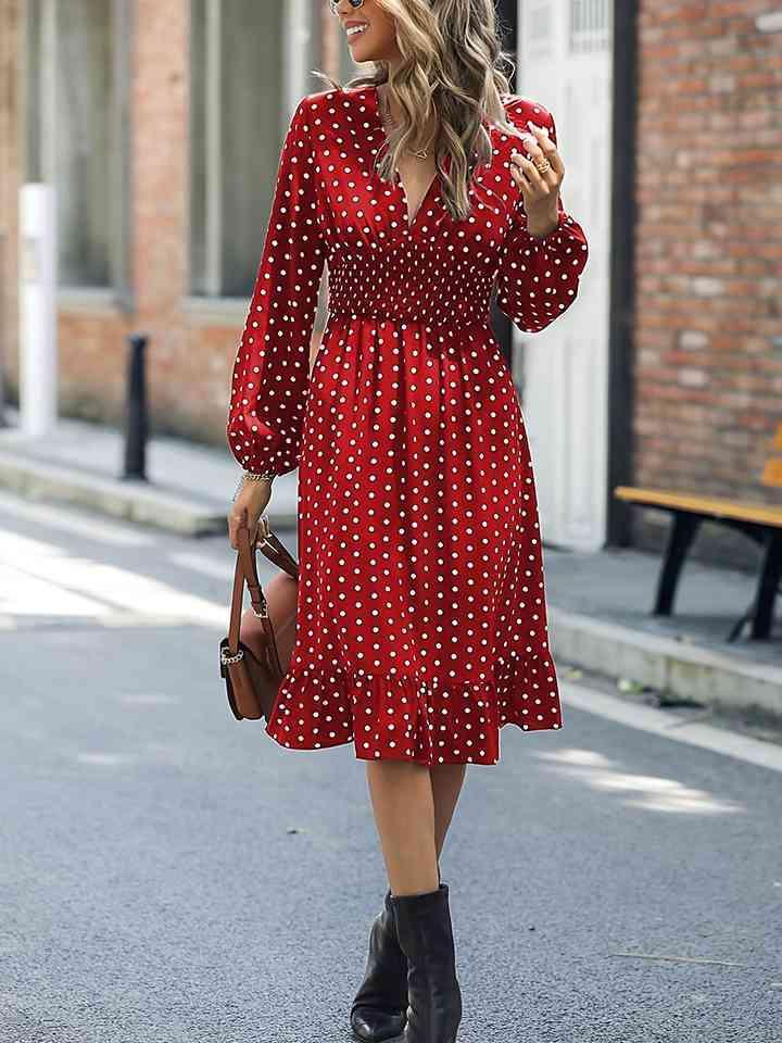 a woman in a red polka dot dress is walking down the street