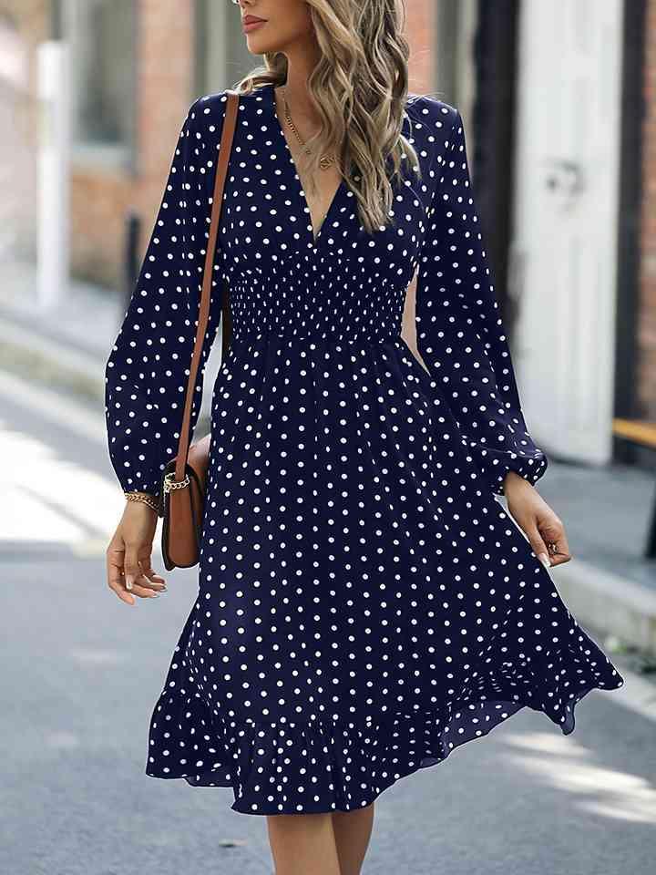 a woman walking down the street wearing a polka dot dress