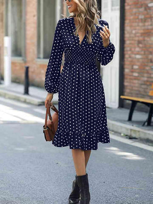 a woman walking down the street in a blue polka dot dress