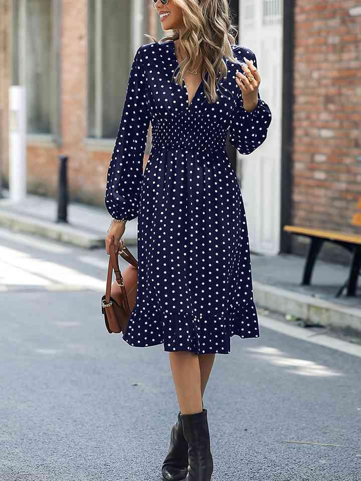 a woman walking down the street in a blue polka dot dress