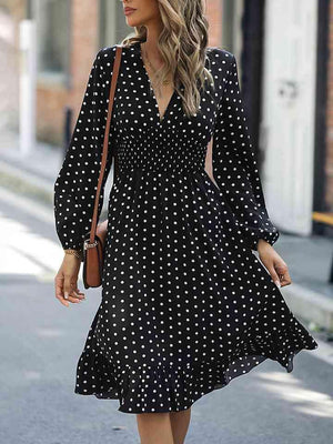 a woman walking down a street wearing a black and white polka dot dress