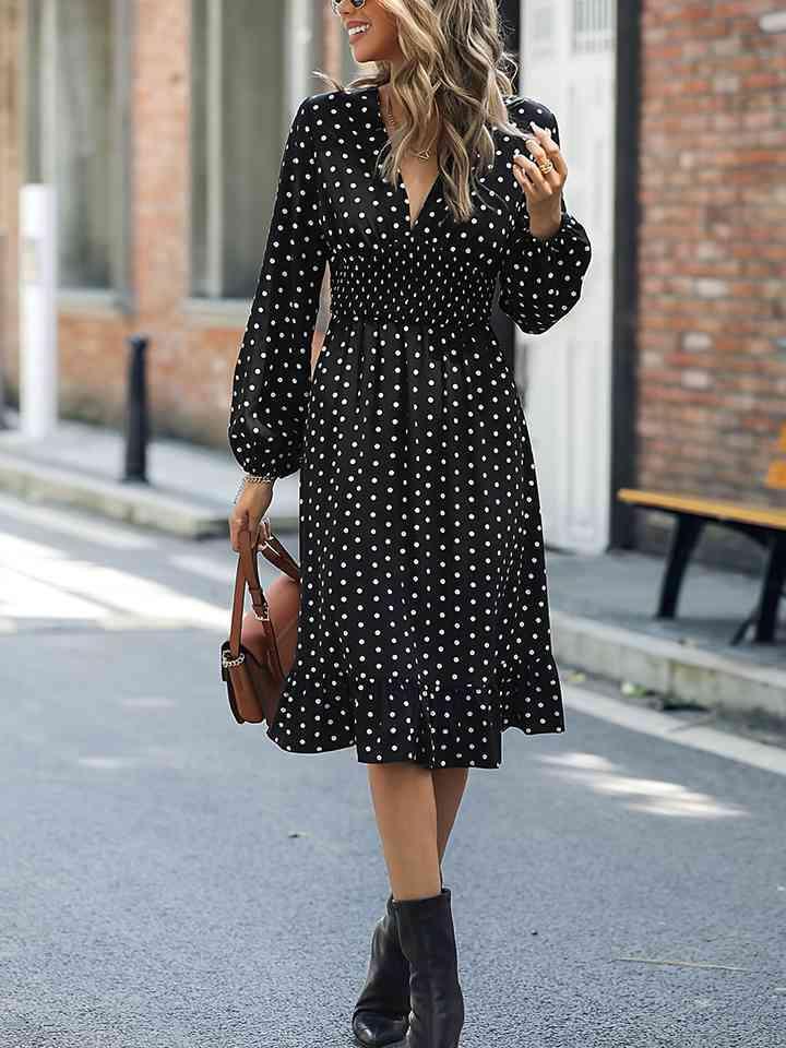 a woman walking down the street in a polka dot dress