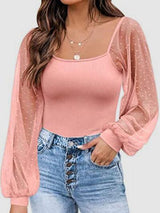 a woman wearing a pink top and jeans