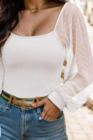 a woman wearing a white top and jeans