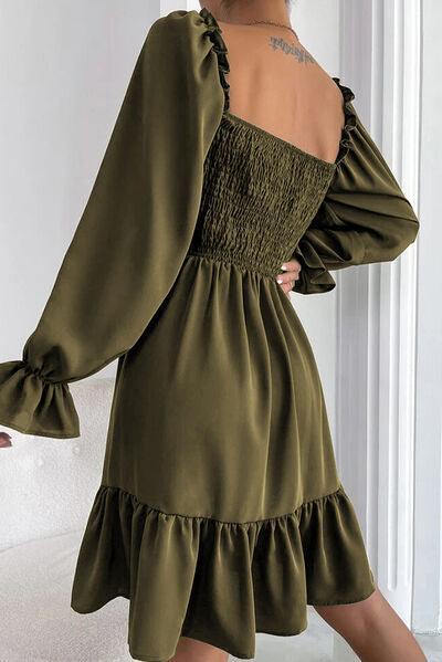 a woman wearing a green dress with ruffled sleeves