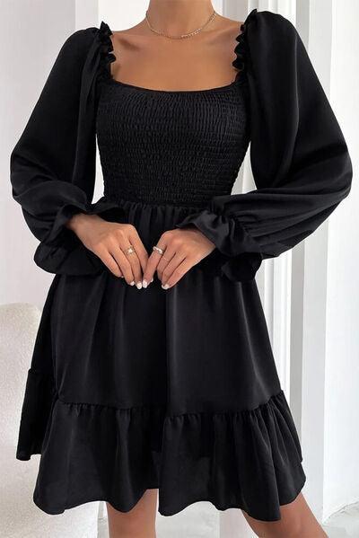 a woman wearing a black dress with long sleeves