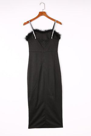 a black dress hanging on a wooden hanger