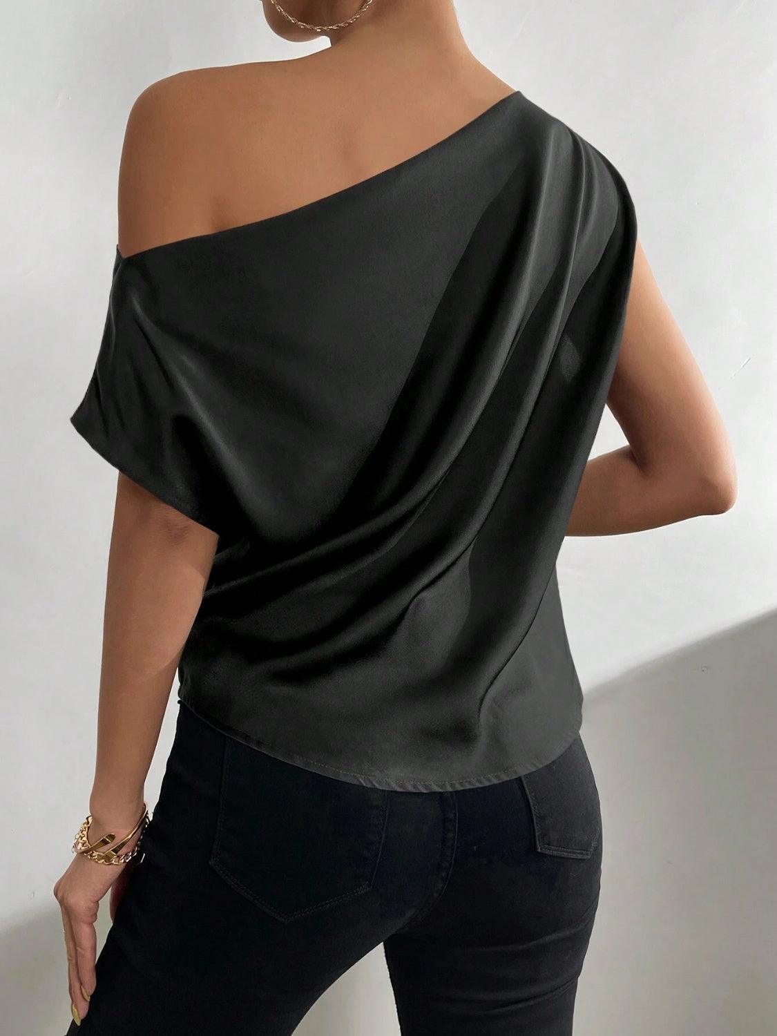 a woman wearing a black top with one shoulder