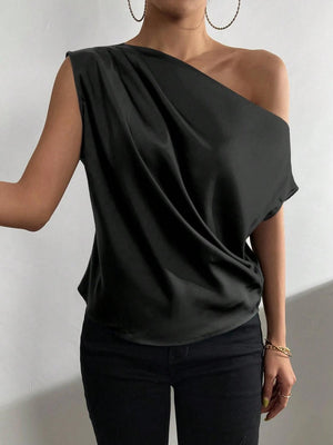 a woman wearing a one shoulder top and black pants