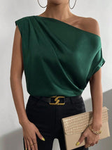 a woman in a green top holding a beige purse