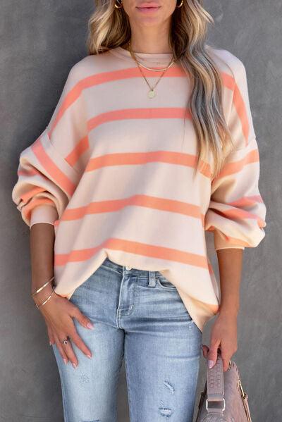 a woman wearing a striped sweater and ripped jeans