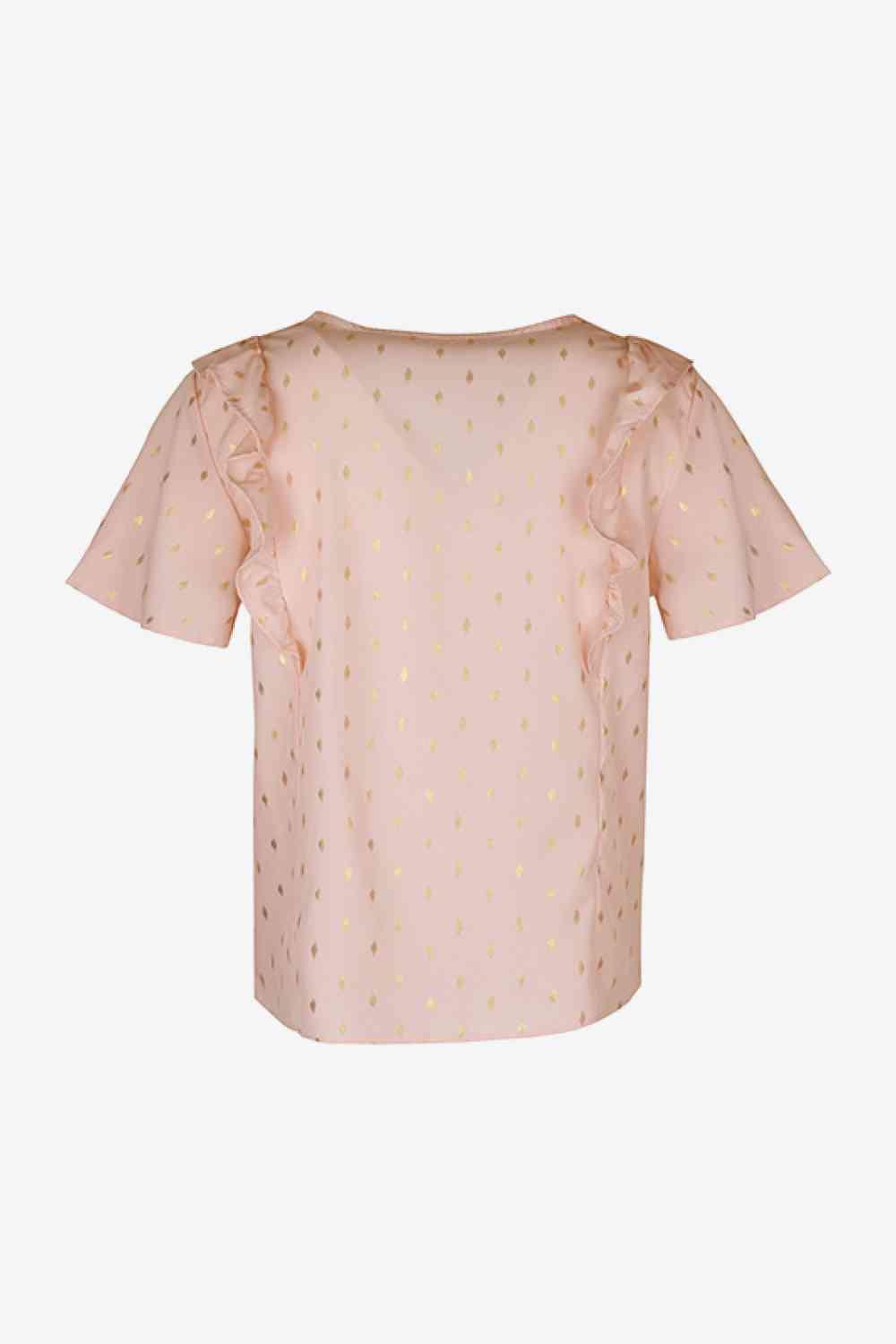 a pink top with gold dots on it