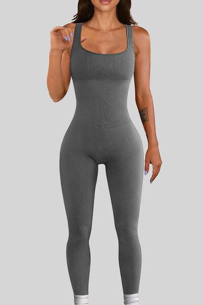 a woman in a grey bodysuit posing for the camera