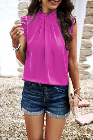 a woman wearing a pink top and denim shorts