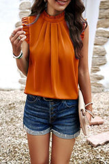 a woman in an orange top and denim shorts