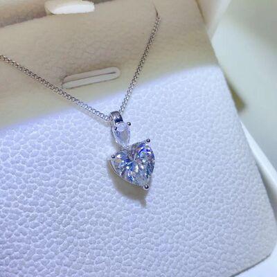 a heart shaped diamond pendant sitting on top of a white box