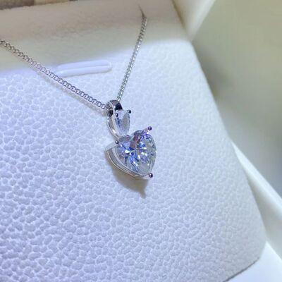 a heart shaped diamond pendant sitting on top of a white box