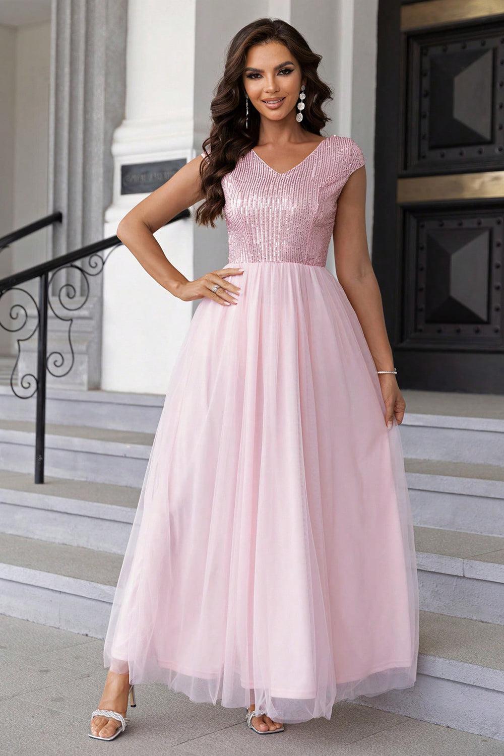 a woman in a pink dress standing on steps