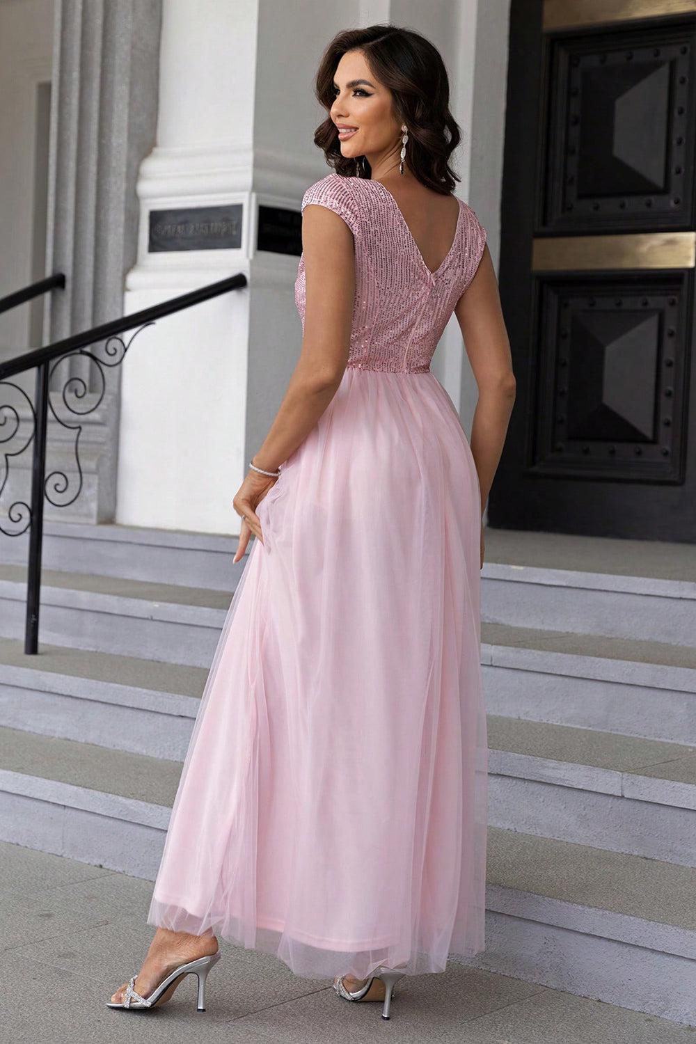 a woman in a pink dress standing on steps