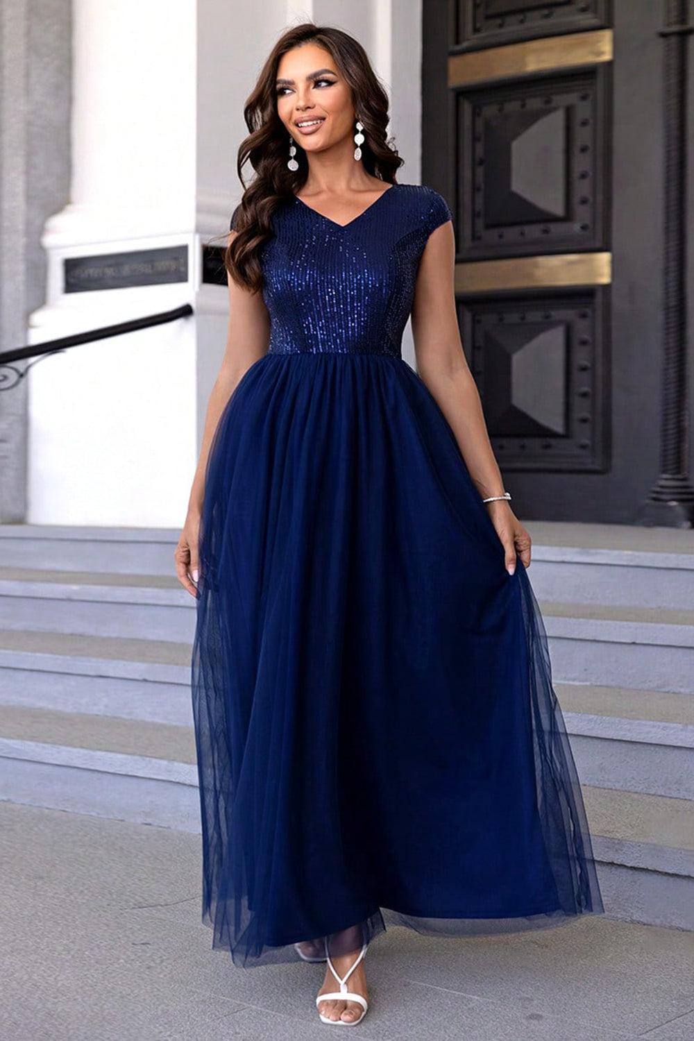 a woman in a blue dress standing on steps