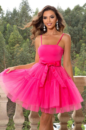 a woman in a pink dress posing on a balcony