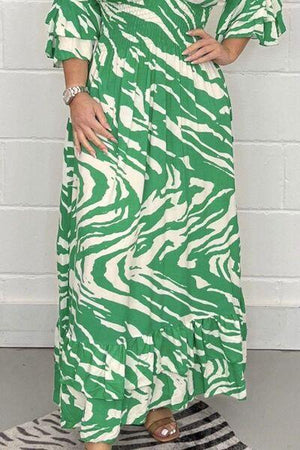 a woman wearing a green and white zebra print dress