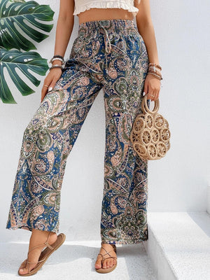 a woman in a crop top and paisley print pants