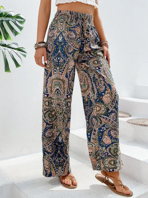 a woman wearing a crop top and paisley print pants