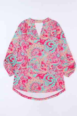 a pink and blue top with a flower pattern on it