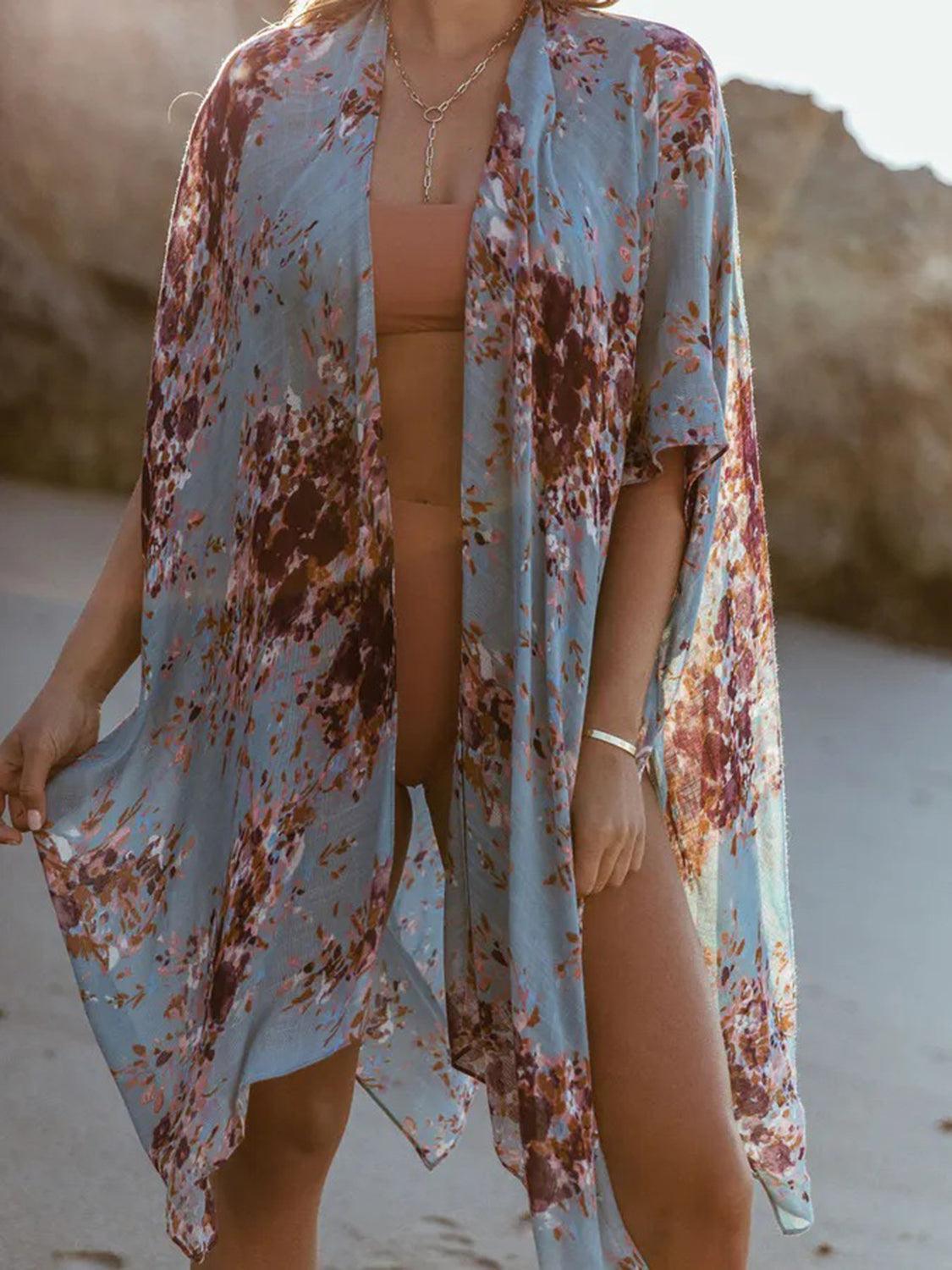 a woman standing on a beach wearing a blue and brown cover up